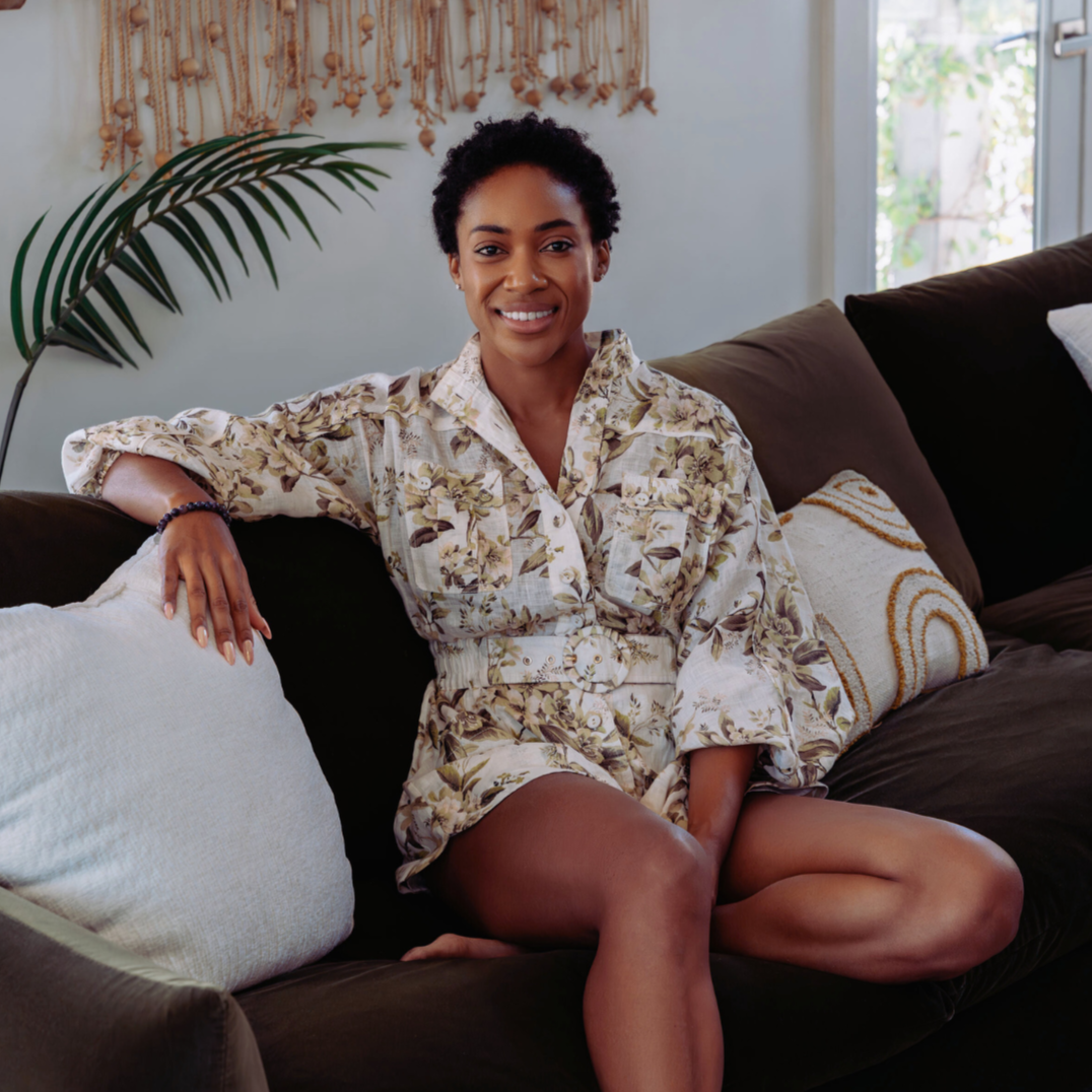 Brooke Sharpton founder of Almond Wind sitting on Valicia Sofa.